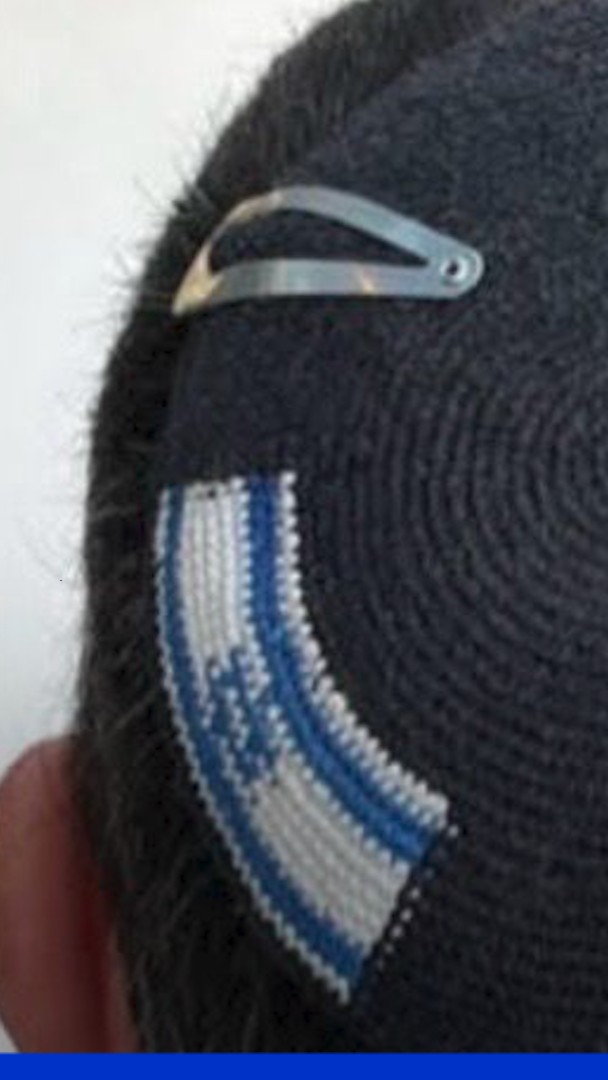 A man named Alex Sinclair was arrested in Israel for wearing a kippah with both Israeli and Palestinian flags. Police called it illegal, took it, and returned it cut—removing the Palestinian flag.
