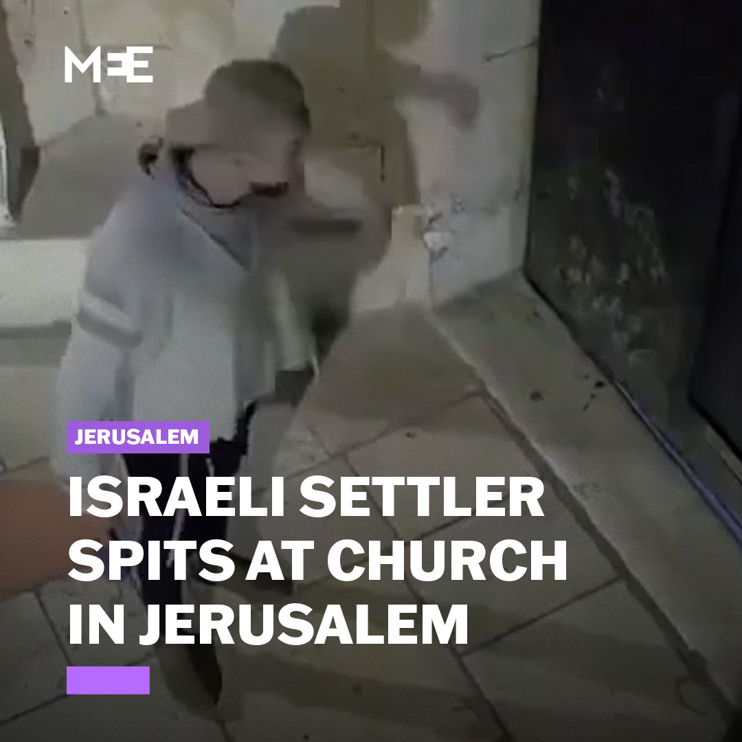 Security camera footage shows an Israeli settler deliberately desecrating the entrance to the Cathedral of Saint James in Jerusalem. The individual is seen spitting at the entrance of the church while staring provocatively into the camera. He proceeds to spit multiple times towards the entrance of the church, then raises his middle finger while simultaneously using his other hand to mockingly form the shape of a cross.