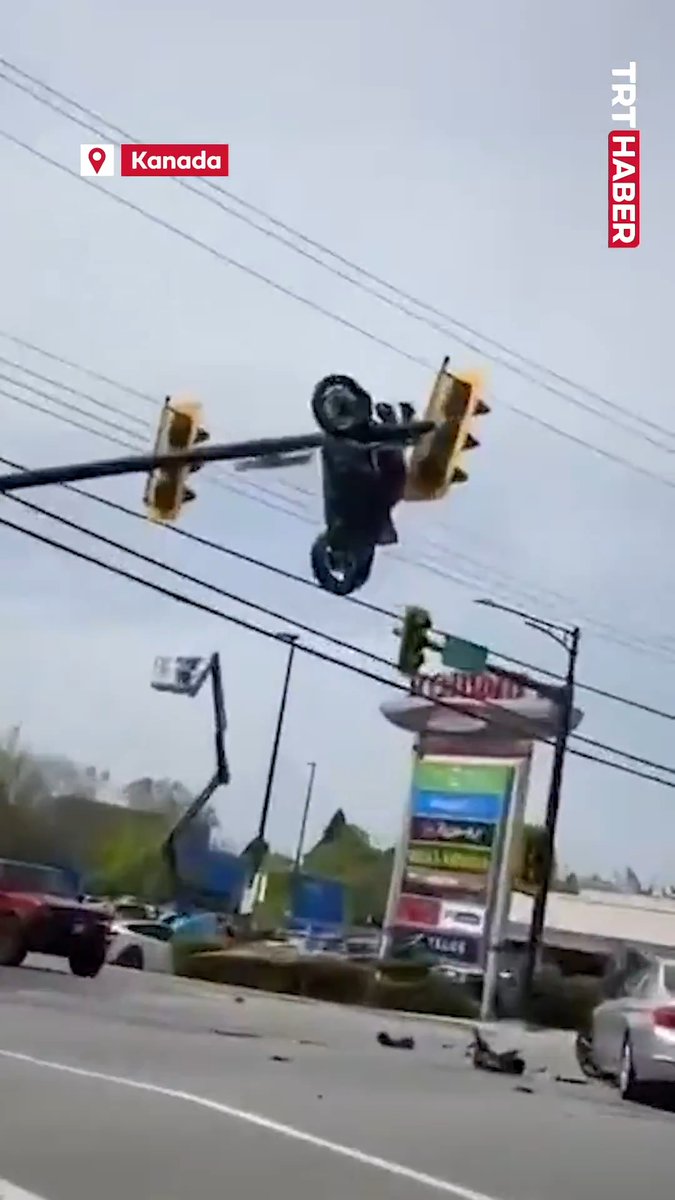 Kanada'da kazaya karışan motosiklet, trafik lambasında asılı kaldı.
