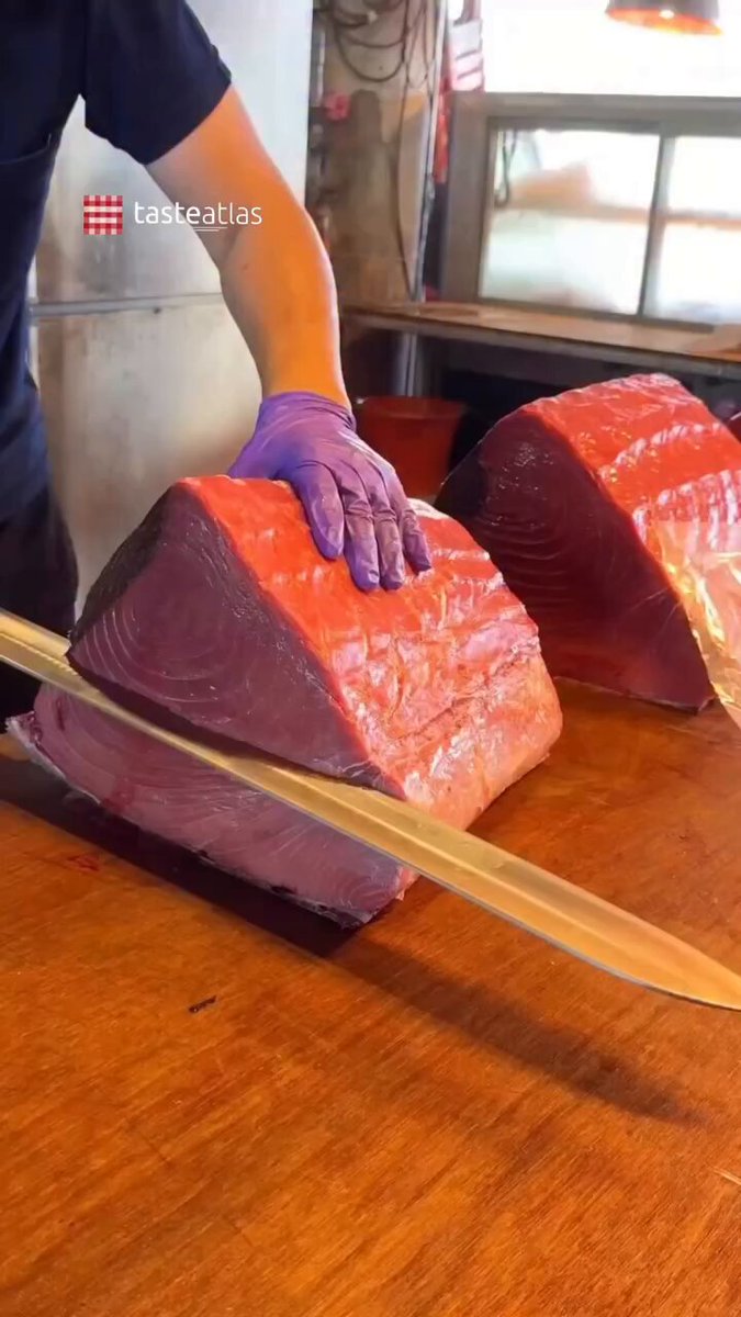 Bluefin Tuna Cutting 🇯🇵 Taste Japan: Few culinary rituals match the awe of a traditional bluefin tuna (maguro) cutting ceremony in Tokyo. Watching a master fishmonger precisely break down a giant fish, often weighing over 200 kilograms, is not just preparation, but a masterclass in centuries-old Japanese craftsmanship. Using specialized, sword-like knives, artisans navigate the massive fish to separate it into three legendary cuts, each offering a distinct texture and flavor profile. The lean, ruby-red Akami is found along the spine, offering a firm, clean, and deeply savory taste with a subtle iron undertone. The medium-fatty Chūtoro comes from the belly section, providing the perfect balance of lean meat and rich marbling that melts gently on the tongue. Finally, the rare and luxurious Ōtoro, cut from the lowest part of the belly, is intensely marbled and buttery, dissolving almost instantly as the ultimate delicacy in the sushi world. From the bustling energy of Tokyo’s fish markets to the quiet intimacy of high-end omakase counters, this spectacle represents the pinnacle of sea-to-table dining, where deep respect for the ingredient meets flawless knife technique. Video: @cillll_hub