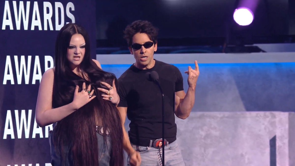 You may know them best as Schaefer & LuSaque from Hacks... Please welcome Meg Stalter & Paul W. Downs! 👋 They're here to present the 🏆 for Best Rock/Alternative Album! #AMAs