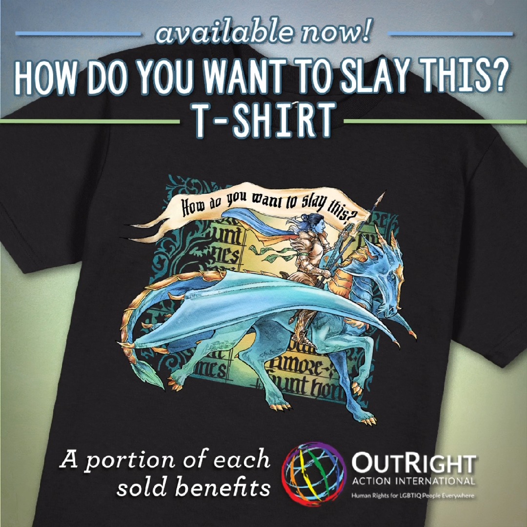 A Stylin' Fit For Dorian Storm 💙🐉 🏳️🌈 🏳️⚧️ Don this gorgeous tribute to Bells Hells' beloved blue boy with our How Do You Want to Slay This? T-Shirt, featuring a striking screen-printed illustration of our airy bard seated atop his dragon mount, alongside a flowing banner emblazoned with the words“HOW DO YOU WANT TO SLAY THIS?” Rep Dorian for a cause! $10 USD from every shirt sold will be donated to OutRight Action International, a nonprofit that works at the international, regional, and national levels to research, document, defend, and advance human rights for LGBTQIA+ people around the world. 💕 FIND YOURS ⬇️ 🇺🇸 🇬🇧 🇨🇦 🇦🇺 🇪🇺