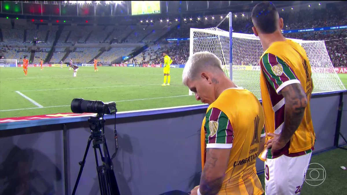 Jogadores do Fluminense assistindo o jogo do Bolívar x Independiente Rivadavia à beira do campo no Maracanã. 📽️ge