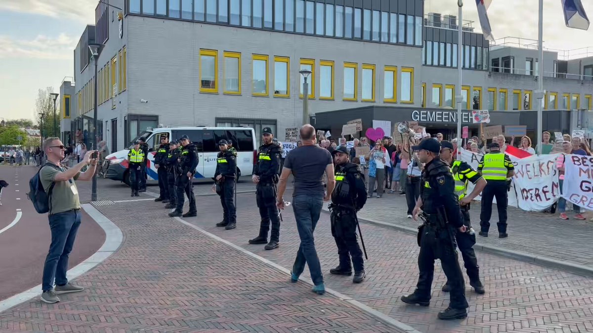 Tegendemonstratie als de mars in #Uithoorn aankomt. Man is er niet blij mee, maar moet terug van de vredeseenheid. Tegendemonstranten worden afgeschermd door Mobiele Eenheid.