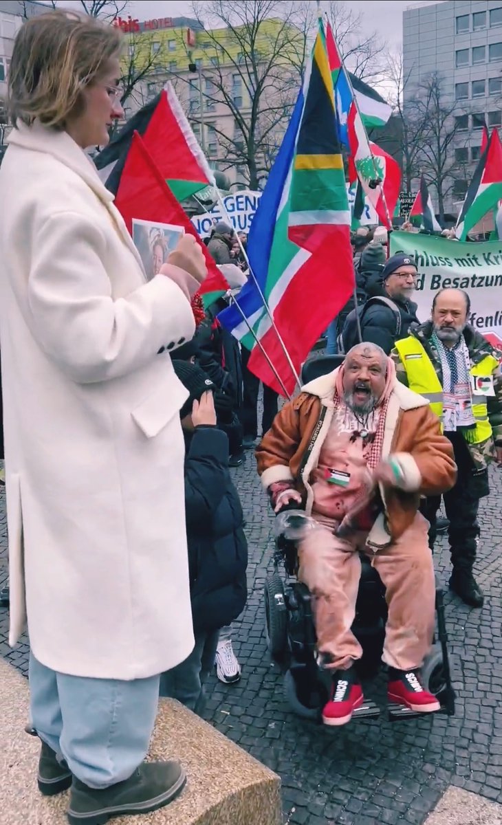 A 🇩🇪German woman is holding up a photo of #ShaniLouk, calling out Hamas for raping girls. Just look at how this wild Palestinian monster loses his mind and starts screaming at her. Why doesn't Germany learn from the HoIocaust and kick these lsIamonazis out ASAP?