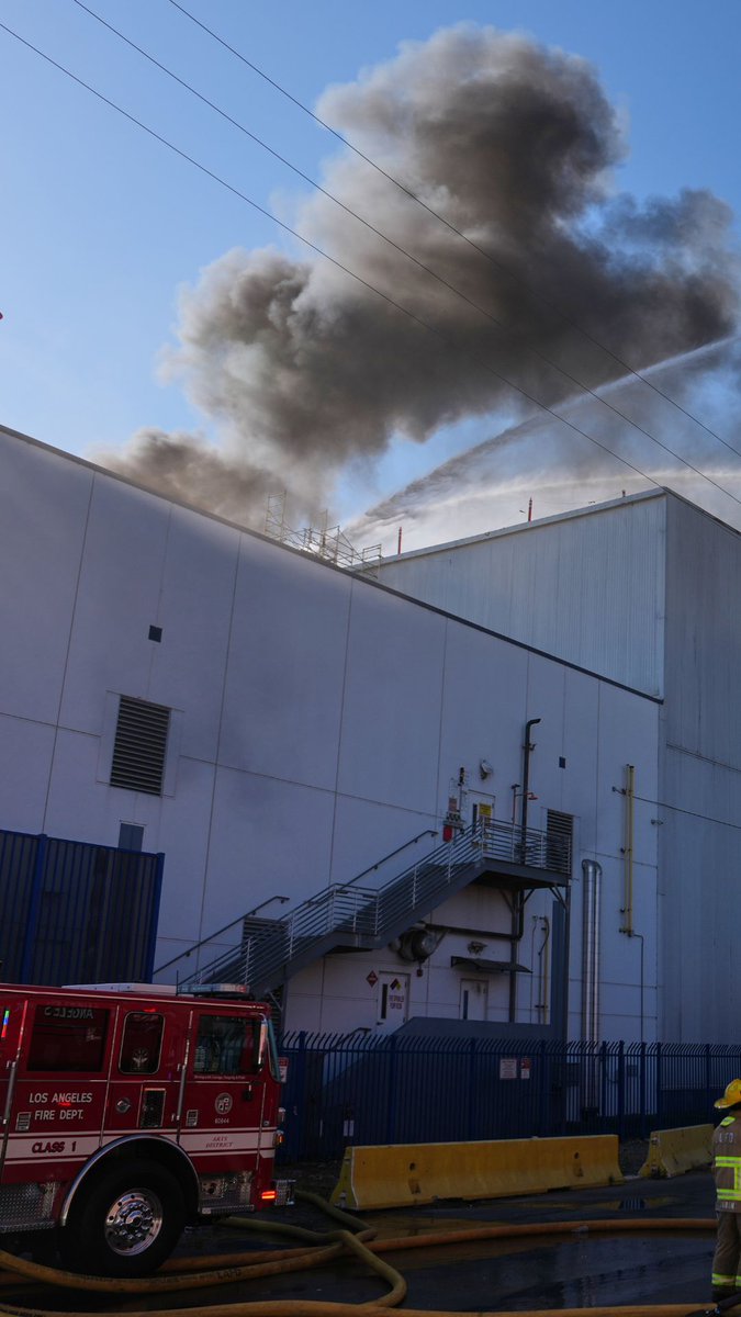 A fire at a massive warehouse blackened the skies near downtown Los Angeles on Wednesday afternoon, prompting shelter-in-place orders in the area due to the risk of hazardous air.