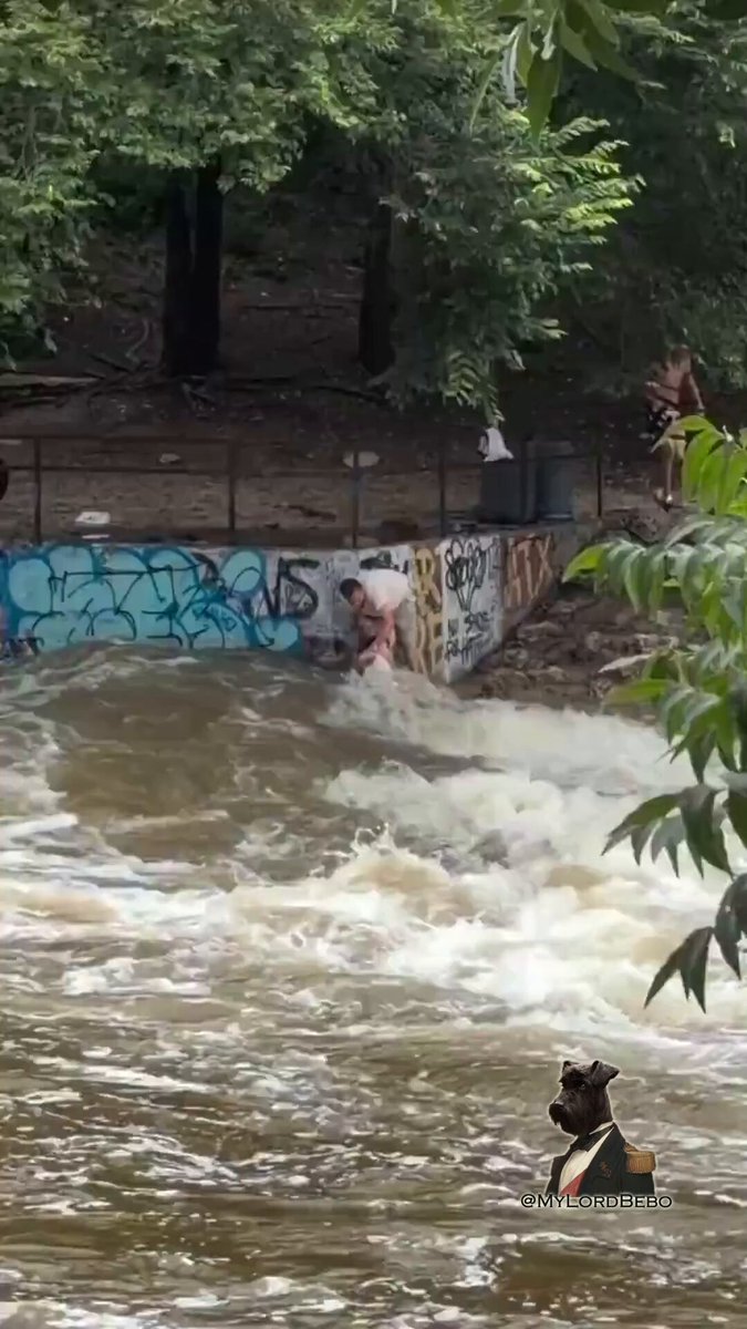 ⁉️Can we all agree this guy deserves the "worst father of the year" award? Dipping a child into fast-moving floodwater is pure insanity