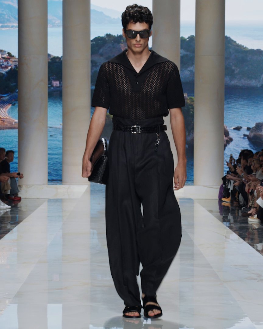VACANZE SICILIANE Sicily is the starting point. The #DGSS27 Men’s Fashion Show opens in Nero Sicilia: an expression of identity and intensity, in which tailoring and detail carry particular force. As the journey unfolds, postcard-inspired prints, handwritten messages and local citrus motifs evoke the spirit of a Sicilian summer, celebrating the island’s landscapes and enduring beauty. Rewatch the show at #DolceGabbana #DGFattoAMano #MadeInItaly
