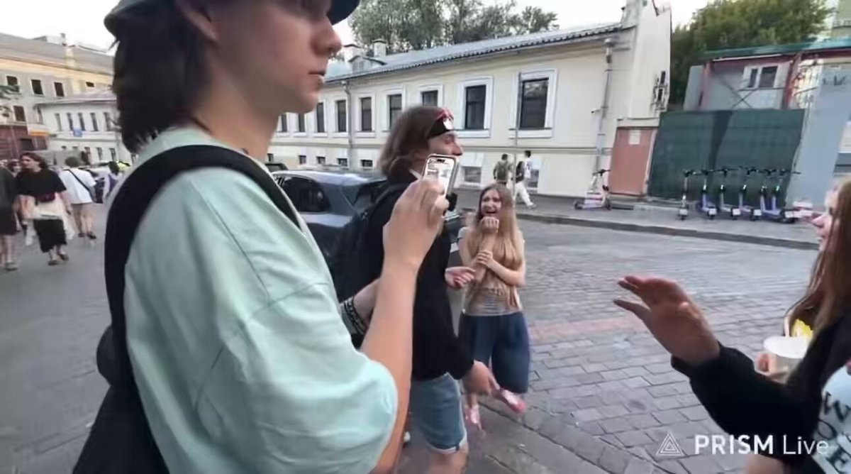 Russian police arrest a young man in Moscow for waving at their police van