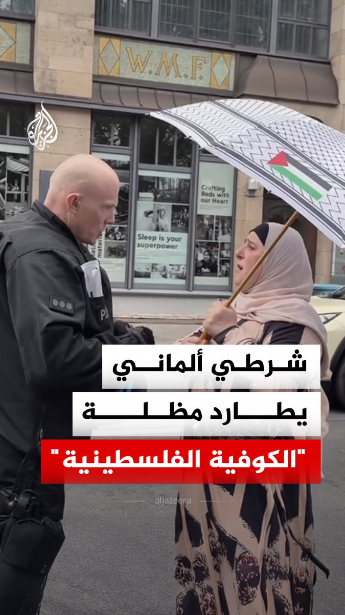 شرطي ألماني يحاول منع سيدة في العاصمة برلين من استخدام مظلة مصممة بشكل "الكوفية الفلسطينية" #فيديو