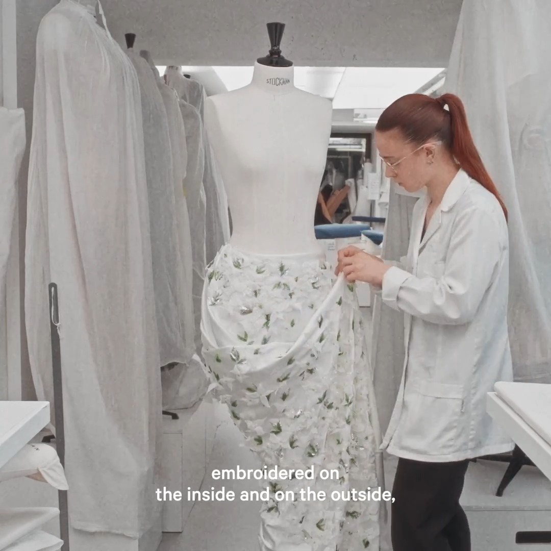 Look 37 from the Dior Fall Winter 2026-2027 Haute Couture Show. White silk satin is embroidered with organza petals and leaves accentuated with beads and sequins, reproducing a cluster of softly fluttering cornus flowers on an asymmetric draped skirt. #DiorCouture