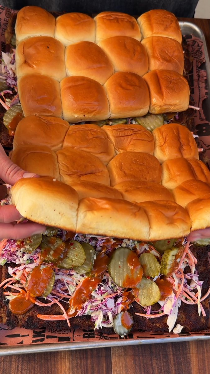 Crispy smashed pulled pork sliders for a crowd. 🔥 Skip the hassle of building sliders one at a time. Stack everything in layers, then slice and serve the whole crew in minutes. Less assembling. More eating. #Traeger #TraegerGrills #Traegerhood #PulledPork #Sliders