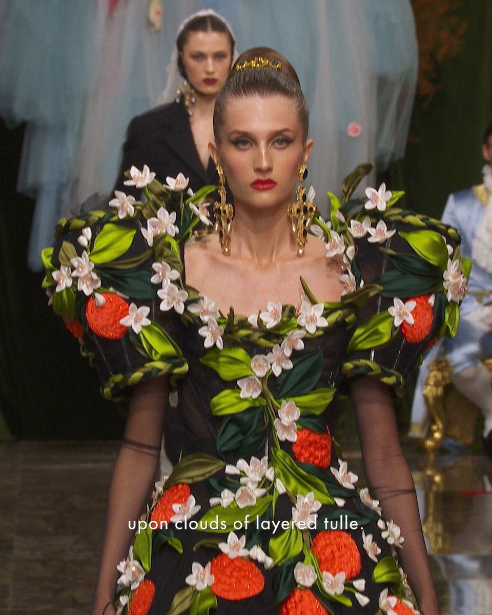 The inspiration behind the #DGAltaModa Collection is rooted in Sicilian terraces, where ornamental terracotta pots safeguard the secrets of timeless villas. As if shaped by the hands of a master potter, oranges and lemons emerge through an interplay of high and low reliefs. Corsets and silhouettes are transformed into creations of pure beauty, immersed in the Radicepura gardens. Glossy leaves and delicate orange blossoms intertwine in a continuous embrace, enveloping the bodice and extending into sleeves, inspired by the sinuous silhouette of an ancient vase. Fruits and tendrils, recreated through the sculptural texture of duchesse fabric and embellished with crystals, rest lightly upon clouds of layered tulle. Rewatch the show at #DolceGabbana #DGFattoAMano #MadeInItaly
