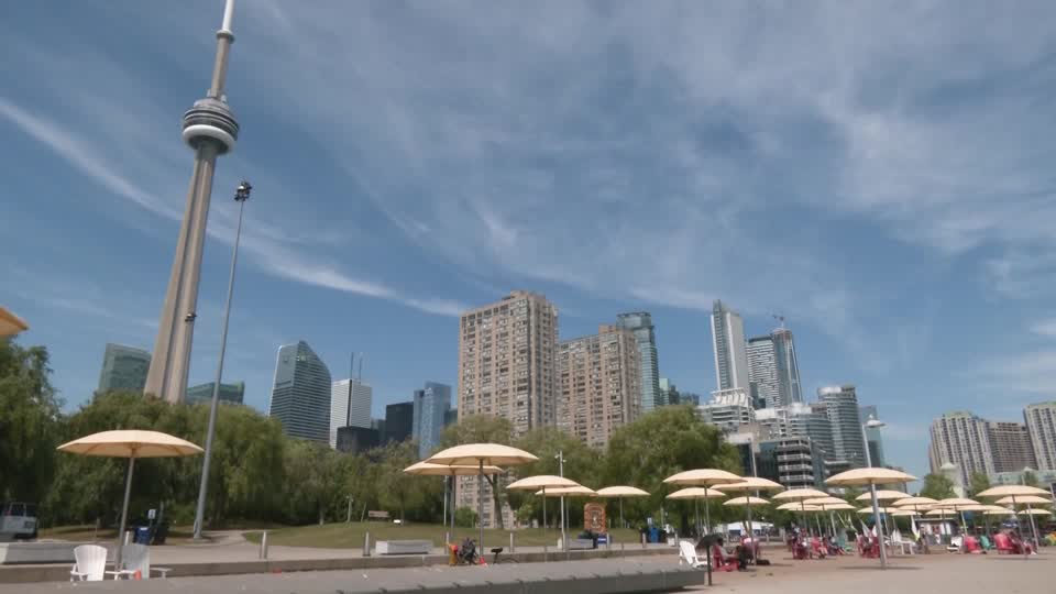 Toronto faces a yellow heat warning as temperatures reach 97 F, with residents using water, shade, sunscreen, and umbrellas to stay safe amid high humidity
