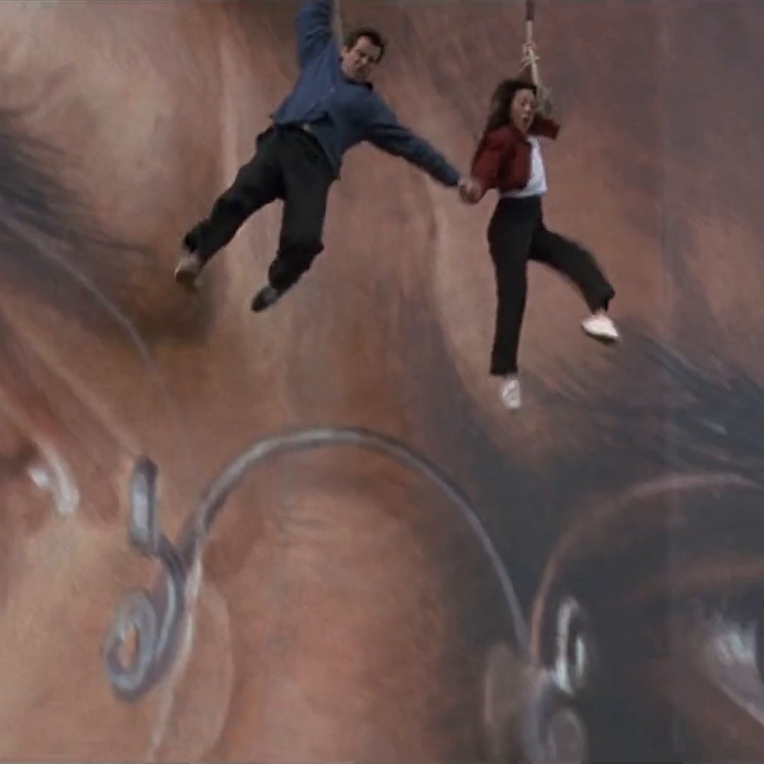 “Next time I’ll take the elevator.” Bond & Lin take a leap of faith using a giant banner to escape Carver’s HQ. A five-story mock-up of the building and banner was created at Frogmore Studios, so that Pierce Brosnan and Michelle Yeoh could film close-ups for the scene featured in TOMORROW NEVER DIES.
