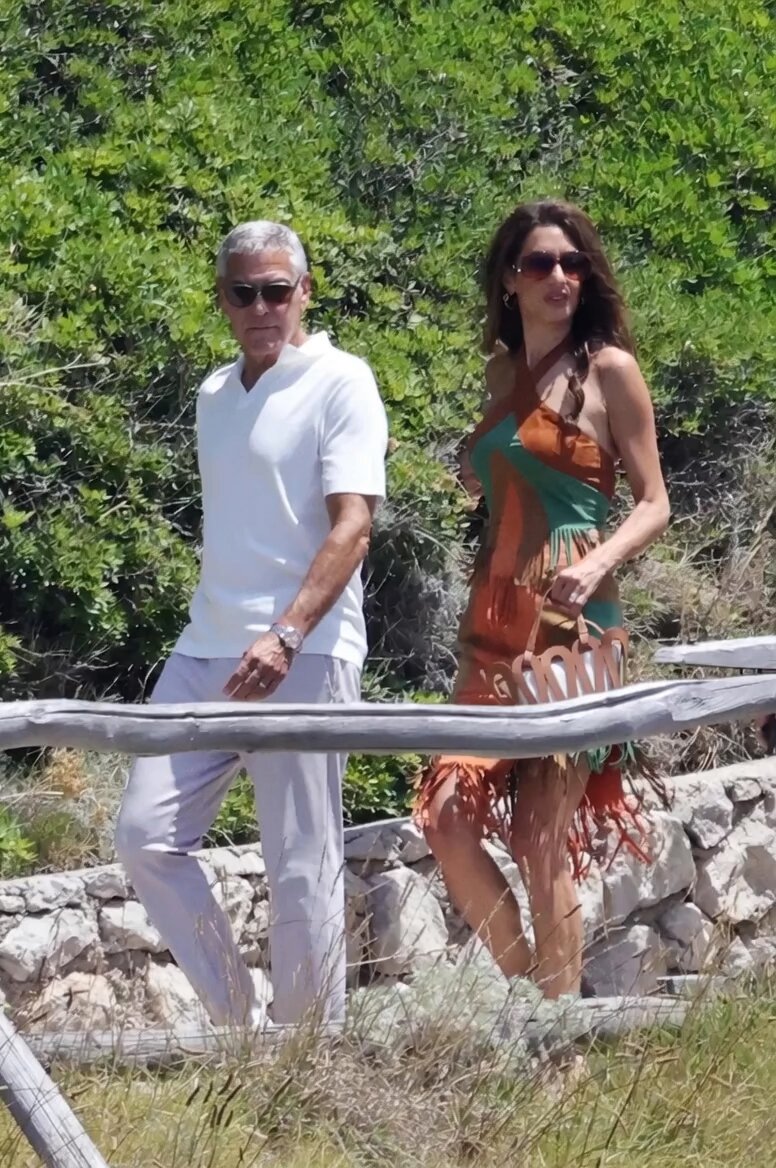 Clooney Summer Vibes in Capri 🇮🇹 George Clooney, 65, and Amal Clooney, 48, enjoyed a stylish boat day in Capri this week. The power couple was spotted arriving by boat, hitting the Il Riccio beach club (with a Dior pop-up), and touring the scenic Villa Bragaglia — a beautiful 1940s hillside estate. Classic Italian summer relaxation! (Video: AI) George kept it effortlessly cool in his usual solid, neutral tones that always suit him perfectly. Amal brought some pleasing colors in a vintage Thierry Mugler suede set — a colorful criss-cross halter top and fringed knee-length skirt in teal, mocha, and orange. Her look strikes me as interesting yet elegant, without a hint of snootiness. Ages are just numbers in adulthood, right? Or does it still matter? What do you think of their fashion choices here — timeless or trend-forward? Do they compliment one another?👇