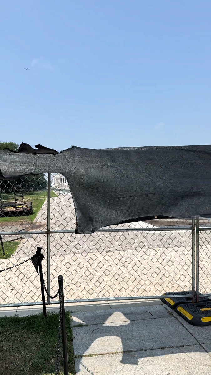 A black tarp seemingly intended to obscure the Reflecting Pool from public view flaps in the wind