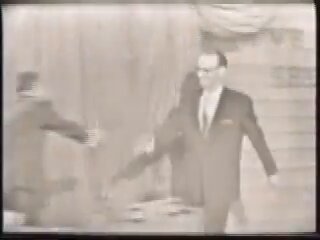 The inventor of television appeared on TV exactly once in his life. As a mystery guest nobody recognized. He won $80 and a carton of cigarettes. July 3, 1957. CBS, "I've Got a Secret." The man is Philo Farnsworth. The panel's job was to guess his secret. The secret on the screen behind him read: "I invented electronic television." They were sitting inside his invention. They questioned him for minutes. Nobody guessed. The backstory makes it worse. At 14, plowing an Idaho potato field, he saw the solution: scan an image line by line, like plowing rows. He sketched the tube on a high school blackboard. At 20 he produced the first all-electronic image. At 24 he held the patent. RCA fought him in court for a decade and history filed him under nobody. The medium he created minted celebrities every night and never learned his face. Watch the panel's reaction at the reveal. Polite applause. Then the host hands the man who built the entire industry $80 and Winstons from the sponsor. The machine forgot its own father. It hasn't stopped forgetting since.