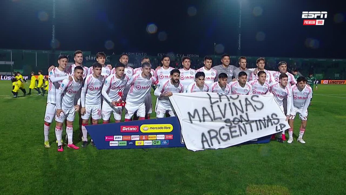"Orgullo argentino" Los jugadores de Argentinos Juniors y Sarmiento de Junín recordaron el triunfo de la Selección argentina ante Inglaterra con la bandera de las Islas Malvinas que desplegó el plantel.
