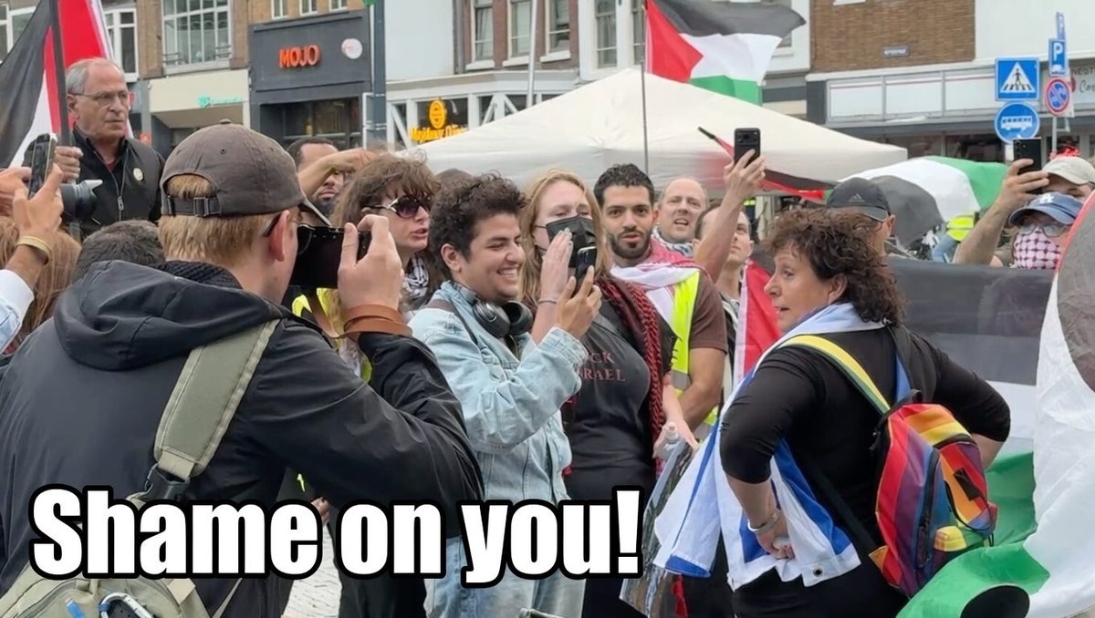 Einde tegendemonstratie op de Neude. Yvonne Hessel wil in haar eentje haar fiets pakken, maar wordt direct omsingeld en belaagd door een schreeuwende 🇵🇸-massa. Een vrouw in haar eentje die zich geen millimeter laat intimideren door het hysterische "Shame on you!"-gejoel vlak voor haar gezicht. Klasse! #Utrecht #Neude
