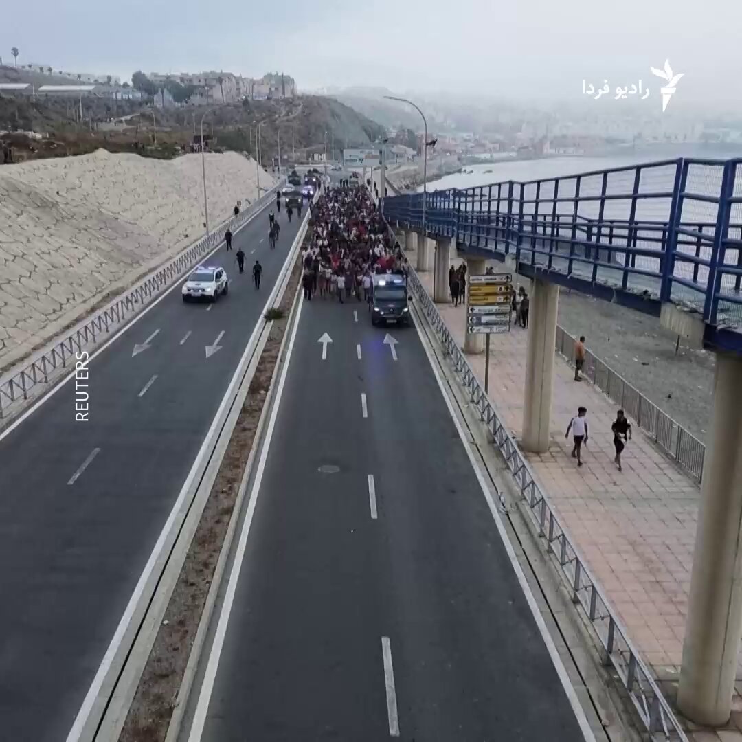 🔸دو روز پس از هجوم هزاران مهاجر به منطقه سبته، اسپانیا از «بازگشت داوطلبانه» بیشتر مهاجران خبر داد. 🔸در تصاویری که رویترز منتشر کرده است دیده می‌شود که گروه بزرگی از این مهاجران توسط پلیس و نیروهای نظامی به سمت گذرگاه مرزی هدایت می‌شوند. 🔸اسپانیا روز جمعه اعلام کرد اکثر بیش از ۵۰ هزار نفری که از طریق خشکی و دریا از مرز عبور کرده بودند، داوطلبانه در حال بازگشت هستند. 🔸نماینده دولت اسپانیا در سبته گفت که ۵۷ جسد در سمت اسپانیایی مرز پیدا شده و ممکن است تلفات بیشتری در سمت مراکش وجود داشته باشد. 🔸بنا بر این گزارش برخی از مهاجران غرق شده‌ و برخی دیگر هنگام تلاش برای بالا رفتن از موج‌شکنی که حصار مرزی روی آن قرار دارد، زیر دست‌وپا مانده‌اند.
