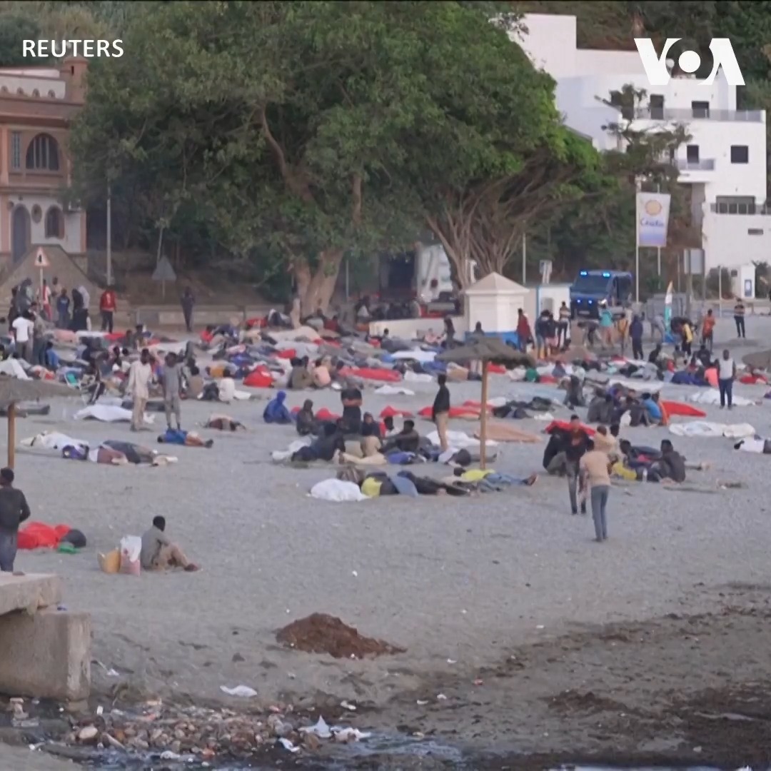 从摩洛哥越境涌入西班牙北非的飞地休达(Ceuta)的移民们8月3日在一处警戒线围起的沙滩露宿。还有一些人在临时移民接待中心外等候。上星期该地区遭遇大规模越境潮，数万人涌入这片狭小领土，令当地有关部门难以应对。西班牙当局说与此次越境潮相关的死亡人数至少达72人。 更多：