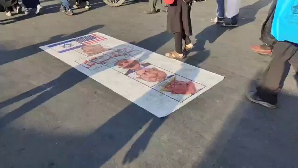 A ground banner with US and Israeli flags and caricatures of Netanyahu and Trump was laid out at Tehran's Arbaeen procession.