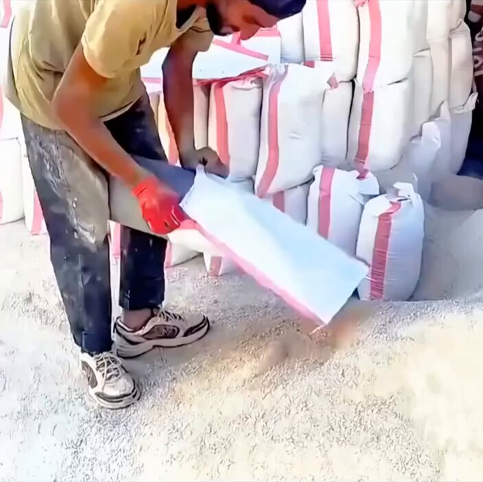 İşçilerin şantiyede kum torbalarını doldurmak için kullandığı pratik yöntem.