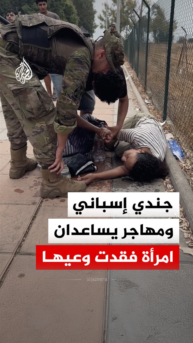 جندي إسباني ومهاجر آخر يساعدان امرأة تعرضت للإغماء، أثناء مرافقة عناصر الجيش المهاجرين خارج مدينة سبتة الخاضعة للإدارة الإسبانية #فيديو