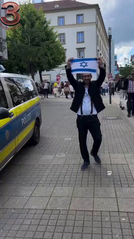 🚨 BREAKING: In Germany, a person walking around with an Israeli flag, unaware that a Palestinian flag had been stuck to his back, became the subject of ridicule.