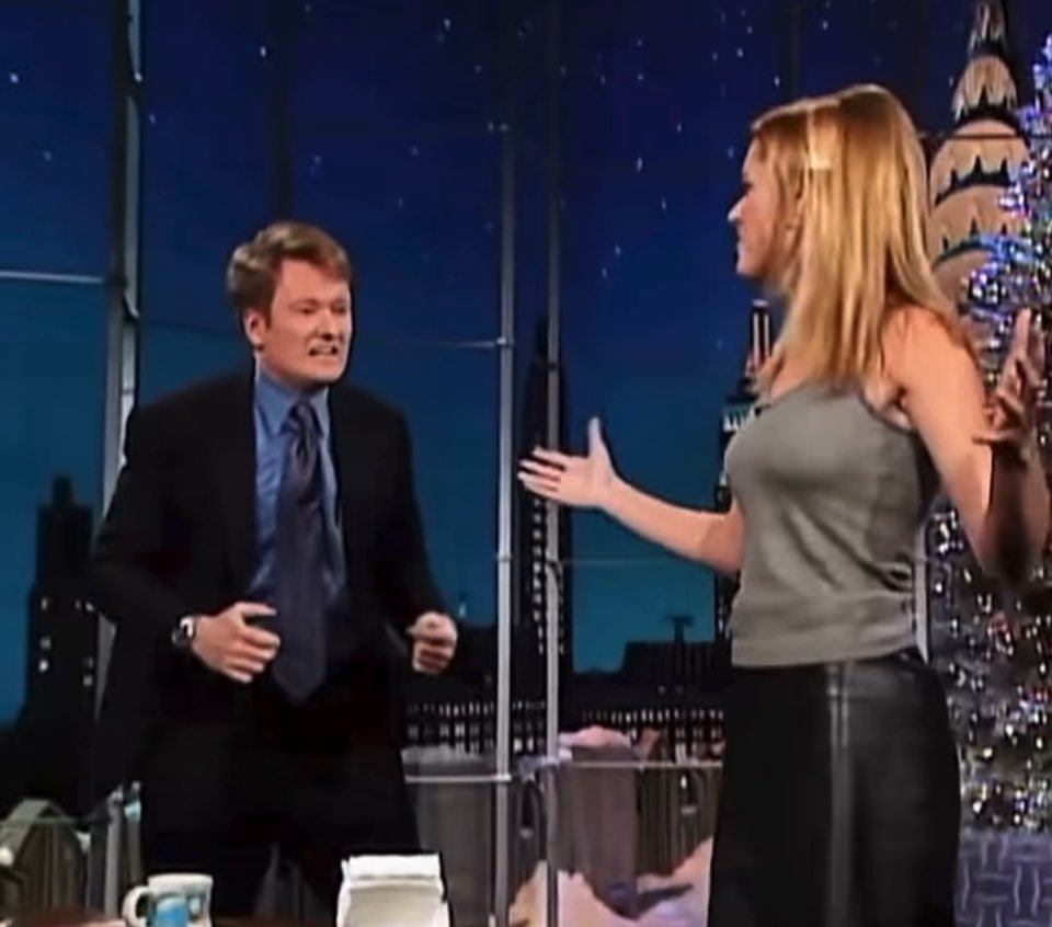 Rebecca Romijn &amp; Conan O’Brien Late Night with Conan O’Brien • 1998 She kisses him. Live on television. Pure 90s chaos.