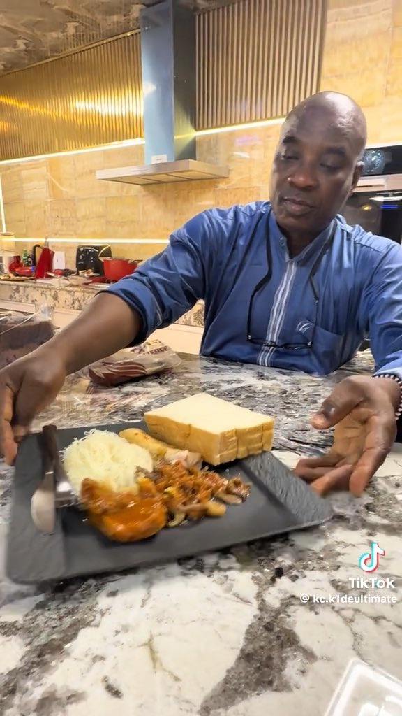 K1 De ultimate serving his band members after cooking, in his kitchen.