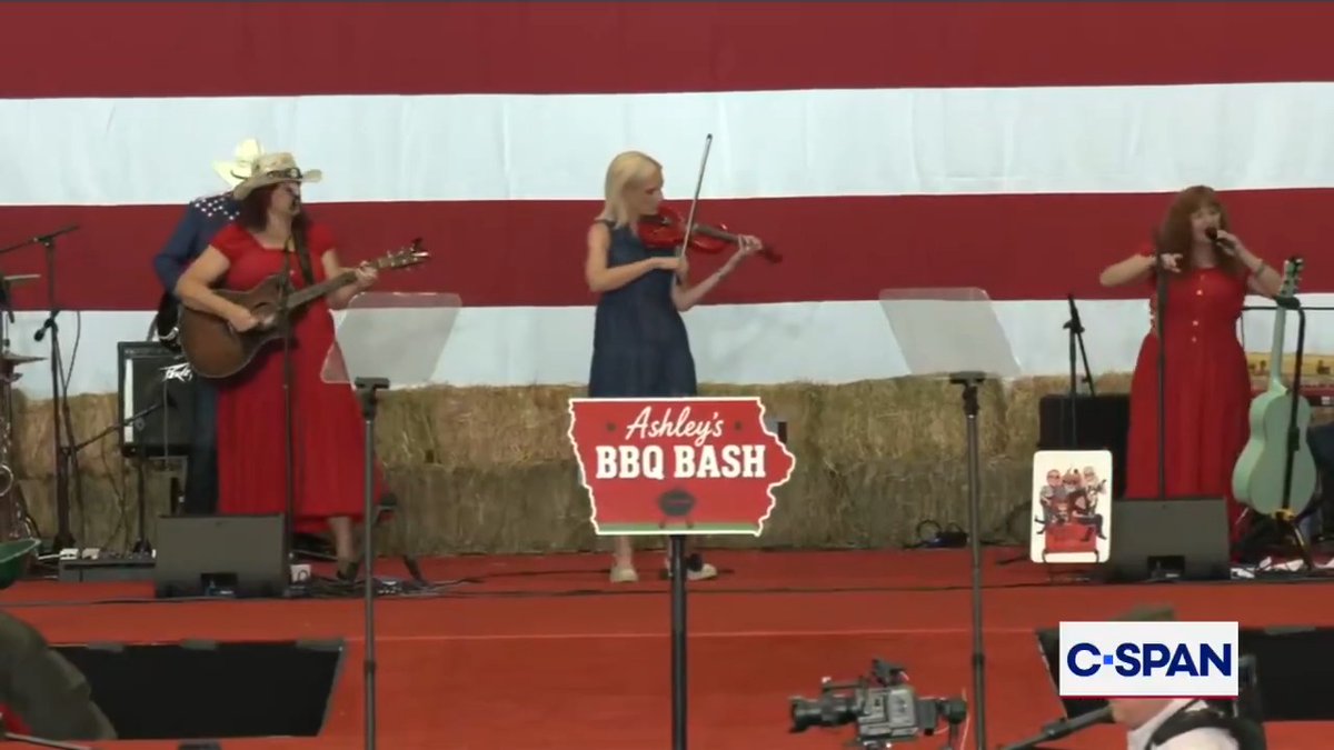 Ashley Hinson (R-IA) plays the violin for a performance on-stage as a tribute to Dolly Parton during a campaign in Clive, Iowa.