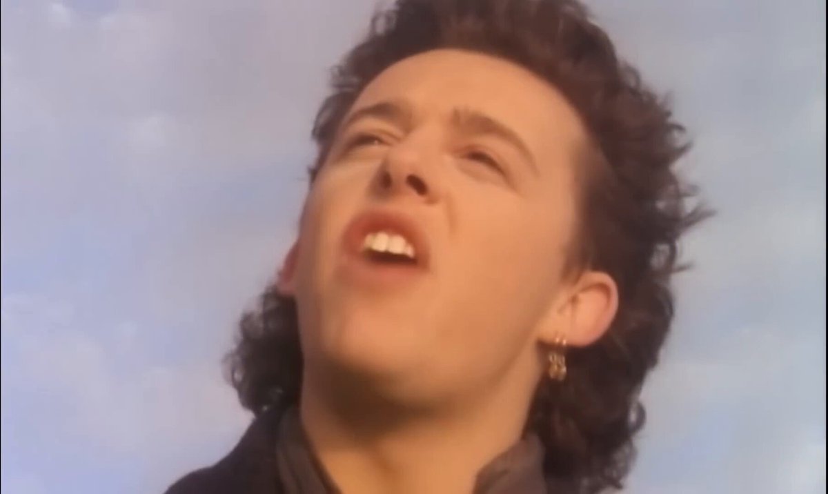 “Shout” is from Tears for Fears’s 1985 album Songs from the Big Chair. Co-written by Roland Orzabal and Ian Stanley, the track became the band's biggest international hit, spending three weeks at #1 on the Billboard Hot 100 and topping the charts in Canada, Australia, Germany, and several other countries. Its powerful chorus and themes of emotional release and resistance to oppression made it one of the defining songs of the 80s. The song's concept was directly inspired by Arthur Janov's Primal Therapy, which proposed that repressed childhood trauma could be released through primal screaming (the same theory that inspired the band's name). Initially considered too long and too dark by their record label to be released as a single, the band insisted on it, and an epic 8-minute 12-inch remix helped propel the song to worldwide success. Beyond its psychological themes, Roland Orzabal also described the lyrics as a broader protest against Cold War-era tensions, oppression, and authoritarianism.