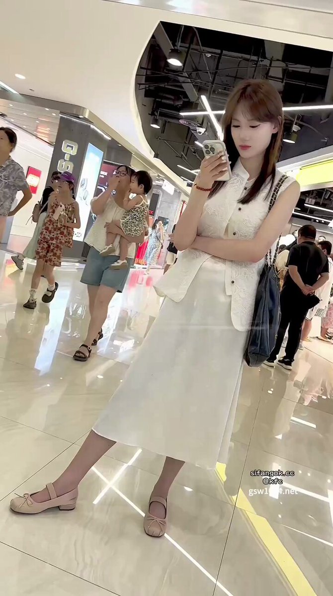长裙轻垂，气质如画的她低头专注手机，眉眼间尽是柔软光影。 而我手中的镜头，悄然捕捉了她每一瞬不经意的惊艳。 她浑然不觉，却已让人心动到欲罢不能。