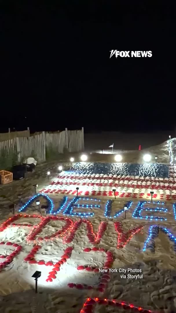 A New Yorker transforms a Long Island beach into a powerful tribute to the lives lost on 9/11, carefully arranging red, white, and blue shells into the Twin Towers, an American flag, and the words "never forget." Suzanne Campbell O’Rahilly created the elaborate display as the nation approaches the 25th anniversary of the Sept. 11 attacks.
