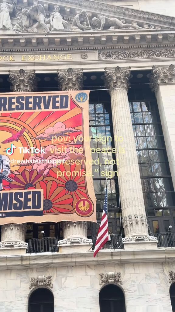 im SORRY? this Sunrise on the Reaping banner hang up at the New York Stock Exchange building are you kidding me