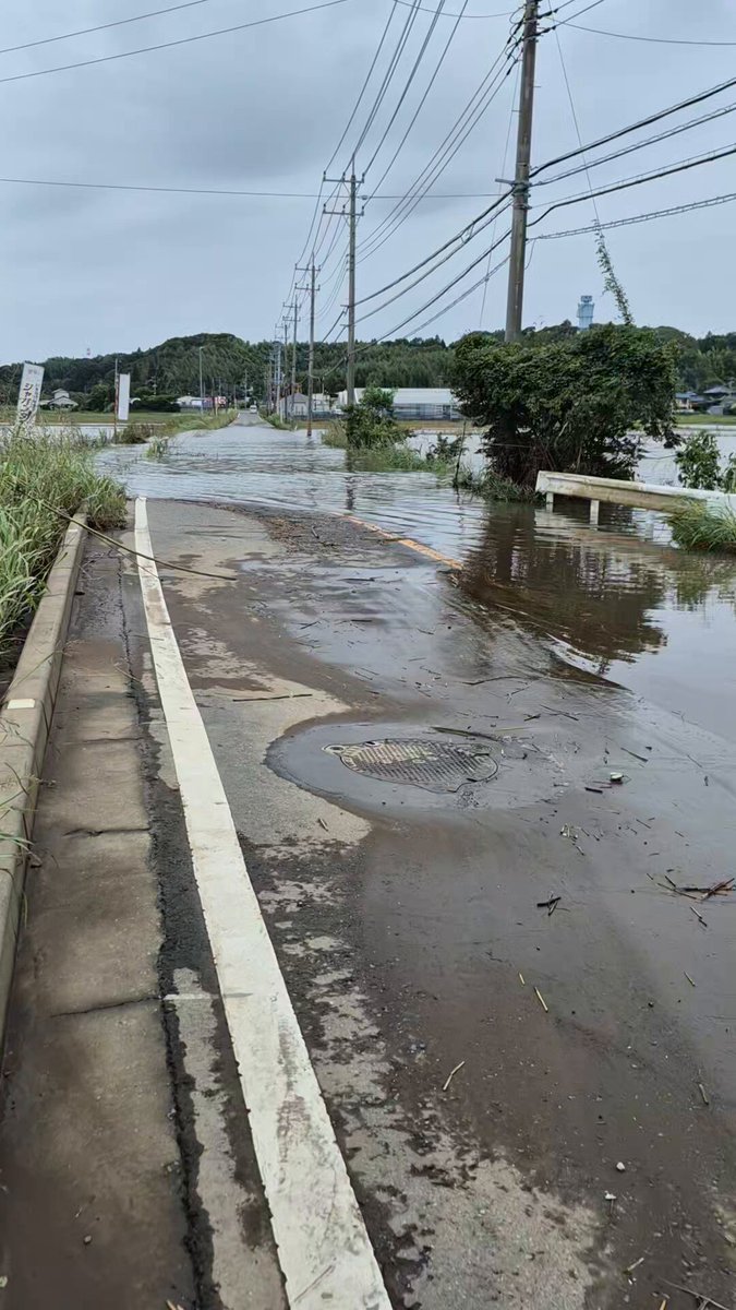 佐倉市の鹿島川の氾濫による幹線道路の冠水箇所。 足下のマンホールからは水が噴き出していました。 道路の片側が水圧で持ち上がり歪んでいるように見えました。 浸水箇所には被災車両が見えます。（人身被害はないとのこと）