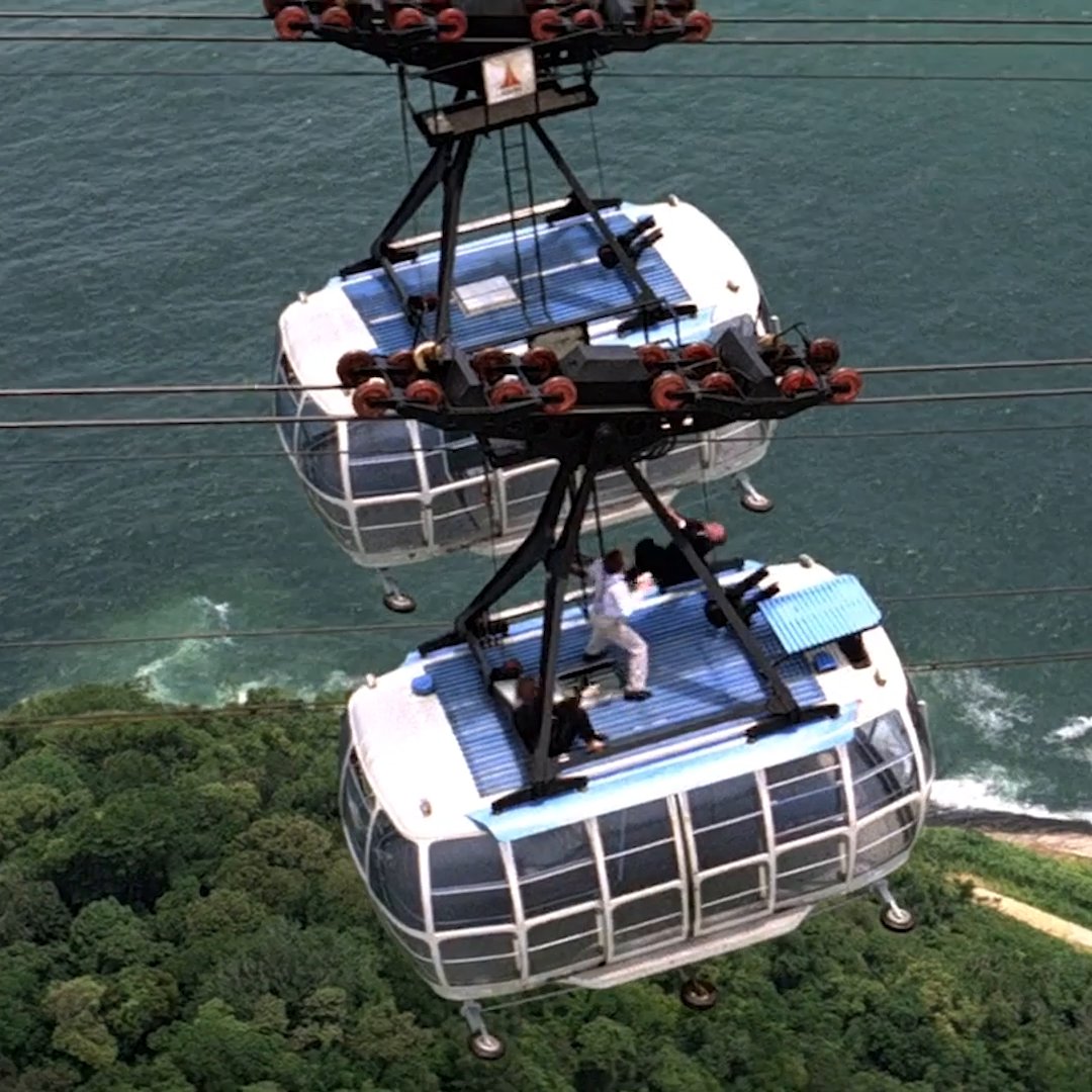 Jaws (Martin Grace doubled for Richard Kiel) pursues Bond (Dickie Graydon doubled for Roger Moore) atop the cable cars in MOONRAKER. The cable car fight was filmed at Sugarloaf Mountain, Rio de Janeiro, and the stuntmen performed without wires. The stunt was originally thought up for the climax of ON HER MAJESTY’S SECRET SERVICE.