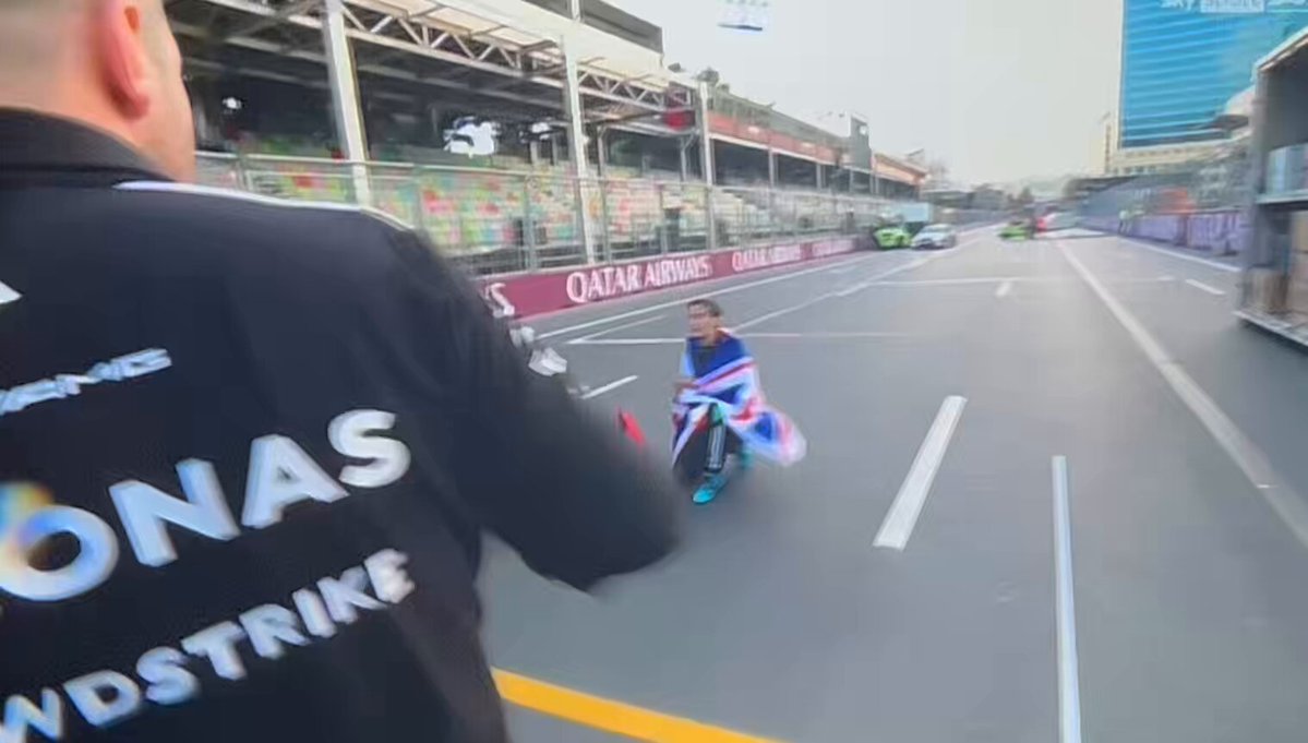 george posing with his trophy and the union jack on the race track and he’s looking so cutieful 🩵