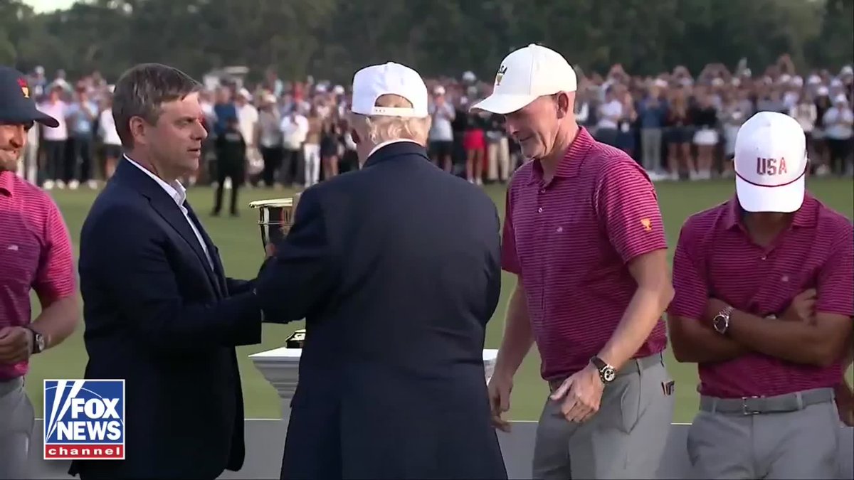 NEW: President Trump presents the Presidents Cup trophy to U.S. Team Captain Brandt Snedeker as Team USA celebrates its victory at Medinah Country Club in Illinois. The U.S. Team defeats the International Team 17-13 following Sunday's singles matches, closing out four days of competition with the trophy ceremony.