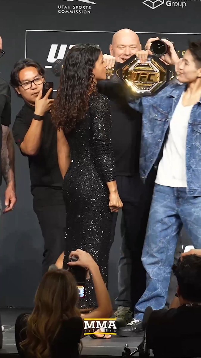 Wang Cong pretends to snatch the belt during their faceoff with Natália Silva at the #UFC332 press conference in Salt Lake City