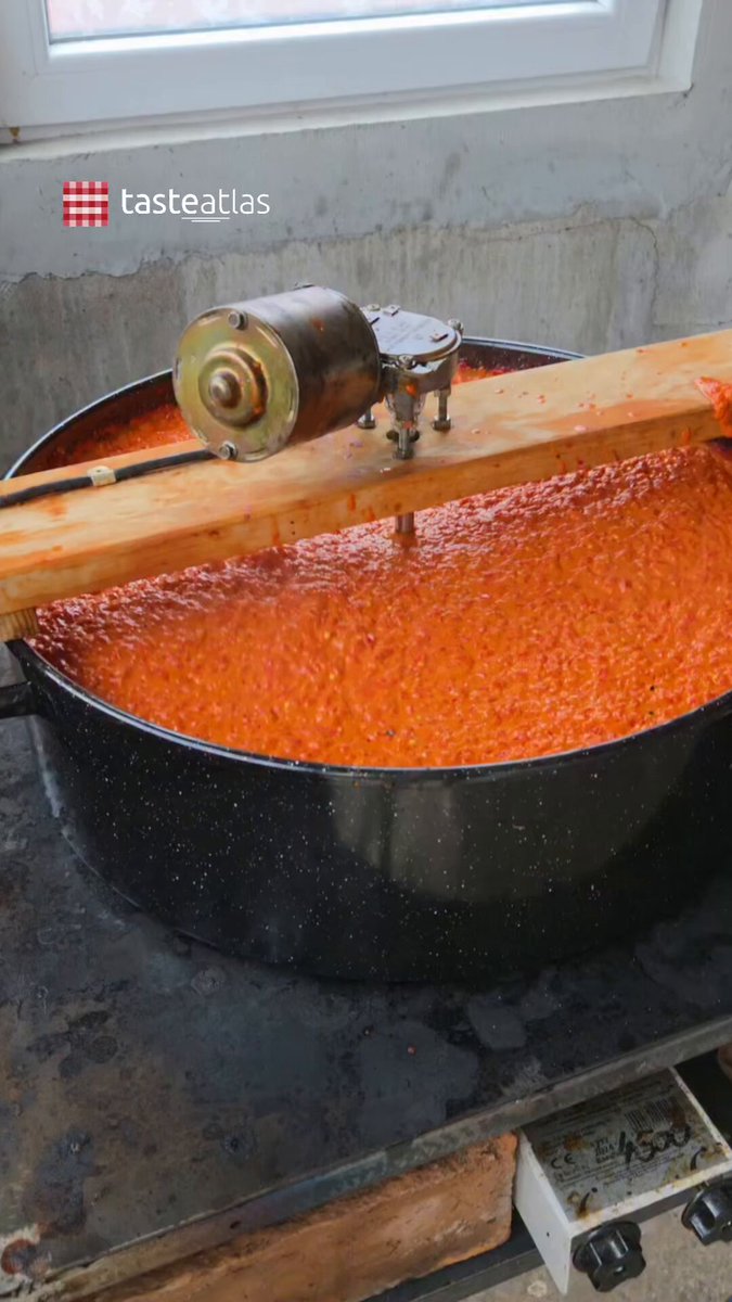 Winter is coming. The Balkans are getting ready. 🇷🇸 🇲🇰 🇧🇦 🇭🇷 🇲🇪 🇸🇮 Autumn means sacks of red peppers, blackened skins and big pots of ajvar. This roasted pepper spread is made across the Balkans, especially in Serbia and North Macedonia, with recipes changing between countries and households. Some include eggplant, others use only peppers, with enough chilli to suit whoever’s filling the jars. The peppers are roasted, peeled and ground, then slowly cooked with oil as part of zimnica, the food preserved for winter. That usually means hours at the pot with a wooden paddle, but some cooks now put homemade motorised stirrers to work, like the one in this video. The motor takes over the repetitive stirring while the ajvar cooks down, ready to be jarred and eaten over the colder months with bread, cheese or grilled meat. Video by: @domaca_prica_by_daca