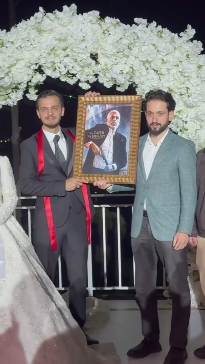 A Turkish man gives his friend a framed portrait of Yahya Sinwar as a wedding gift.